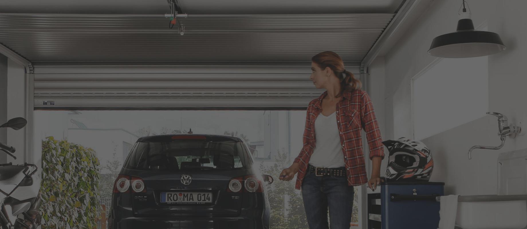 Woman stands in the garage and closes the door via remote control