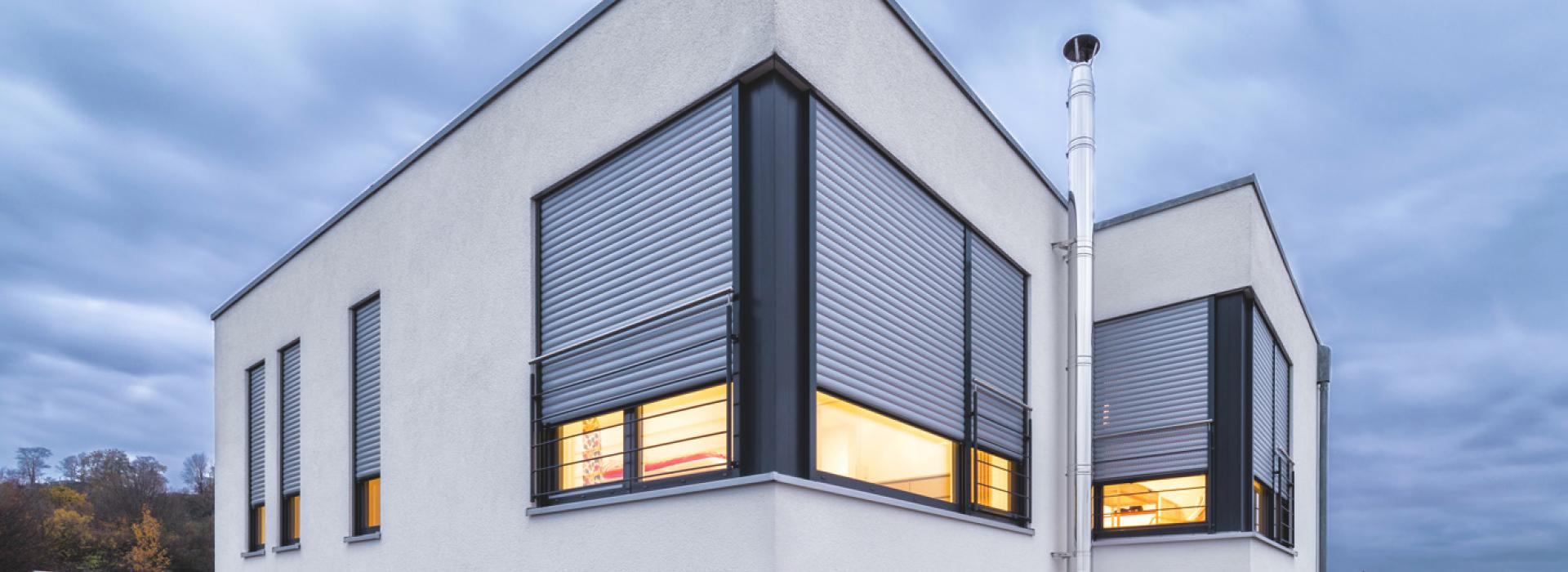 Single-family home detailed view window with nearly closed roller shutters
