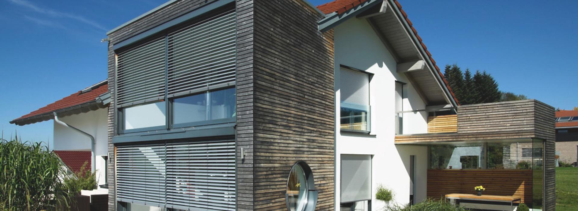 Wooden construction of house with front-mounted external venetian blinds by daylight